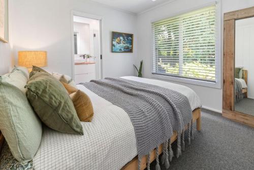 a bedroom with a large bed and a window at PERIWINKLE - MOUNT MARTHA in Mount Martha