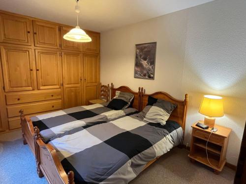 une chambre avec un lit et une lampe sur une table dans l'établissement Appartement spacieux proche du domaine skiable à Châtel, Multi Pass été à 3€/jour/personne inclus - FR-1-693-90, à Châtel