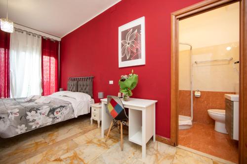 ローマにあるL'Imperiale RomaTrastevereの赤い壁のベッドルーム(ベッド1台付)、バスルームが備わります。