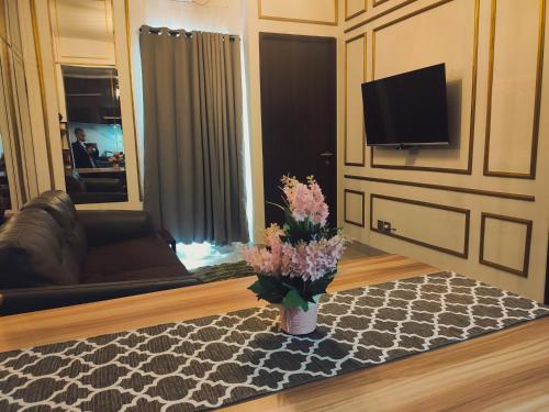- un salon avec un vase de fleurs sur un tapis dans l'établissement Mewah di Transpark cibubur cocok for Bestie & Family, à Kalimanggis