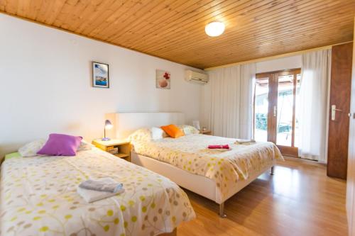 1 Schlafzimmer mit 2 Betten und einem Fenster in der Unterkunft Apartments Mare 1 - close to the sea in Biograd na Moru