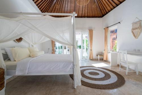 a bedroom with a white bed with a canopy at Isaiya Boutique Hotel in Canggu