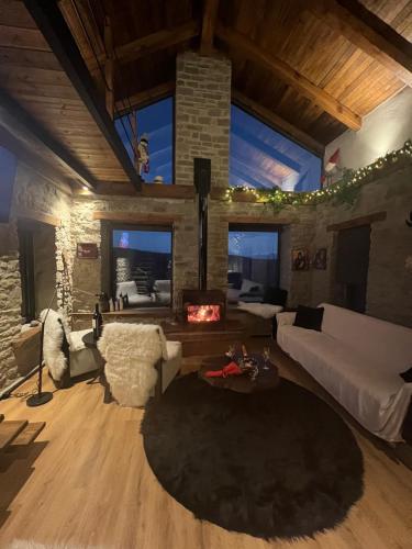 a living room with a fireplace and a stone wall at Villa 18 in Manteio