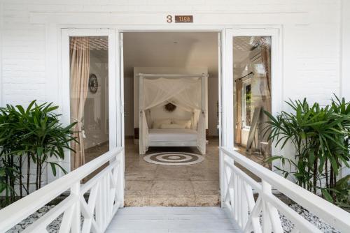 a white porch with a bed on a house at Isaiya Boutique Hotel in Canggu