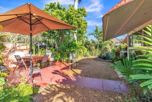 a patio with an umbrella and a table and chairs at Beautiful Comfy Home With Private Hot Tub Close To Beach home in Fort Lauderdale