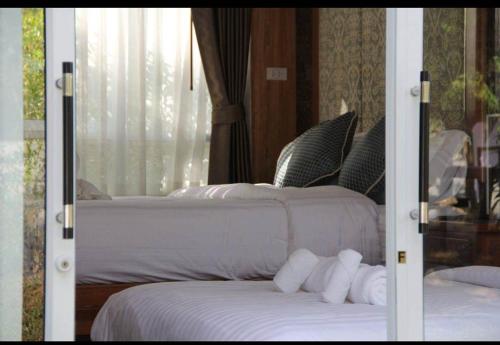 a bedroom with two beds and a window at ภูฝ้ายวิลล่า Phufai villa in Chiang Khan