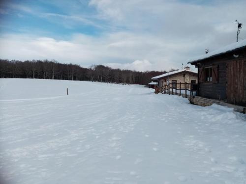 un gran campo cubierto de nieve junto a un edificio en La tana delle coccinelle, en Capracotta