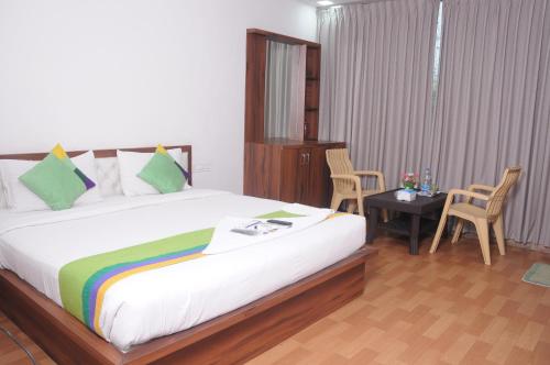 a bedroom with a bed and a table with chairs at J C Comforts in Bengaluru