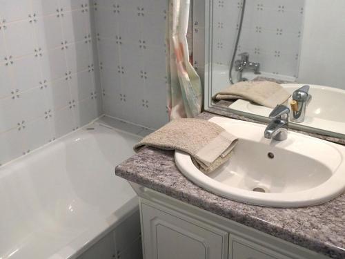 uma casa de banho com um lavatório e uma banheira em Appartement Bagnères-de-Luchon, 2 pièces, 4 personnes - FR-1-313-127 em Luchon