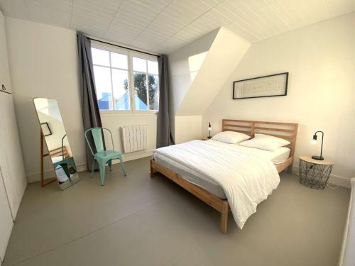 a bedroom with a bed and a chair and a window at Grande Maison Rénovée 3* à Bénodet, Jardin Clos, Salle de Jeux, Parking, Wifi, Terrasse, 4 chambres - FR-1-481-112 in Bénodet