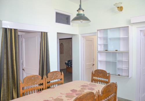 a dining room with a table and chairs at Three bedroom house with private garden in Solan