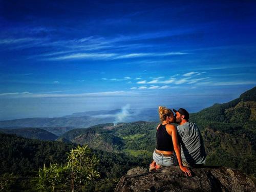 a man and woman sitting on top of a mountain at The Capoe House in Haputale