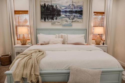 a bedroom with a blue bed with two lamps at Brand new home minutes to Sandpoint and Schweitzer in Ponderay