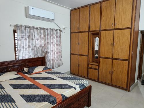 um quarto com uma cama e um armário de madeira em Feel Like Home Rkbeach em Visakhapatnam