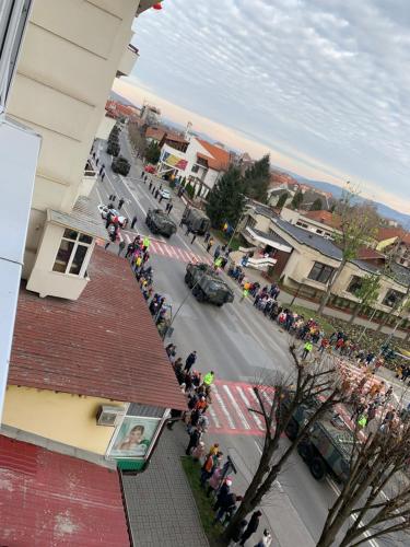 un grupo de personas de pie alrededor de una calle con un desfile en Apartament Carolina Parc en Alba Iulia
