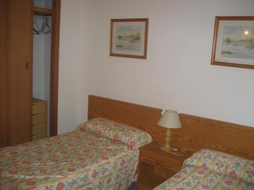 a bedroom with two beds and a lamp on a table at Holiday homes Bonamar in Colònia de Sant Jordi