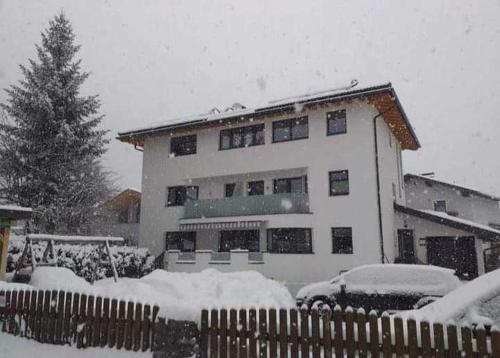 una casa cubierta de nieve con una valla delante en Appartement Spiss, en Ried im Oberinntal
