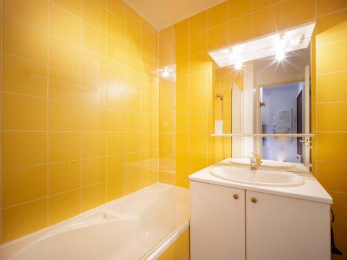a yellow bathroom with a sink and a bath tub at Appartement Peyragudes, 2 pièces, 6 personnes - FR-1-695-2 in Germ