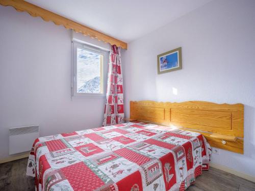 a bedroom with a bed with a red and white quilt at Appartement Peyragudes, 2 pièces, 6 personnes - FR-1-695-3 in Germ