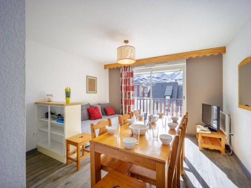 une salle à manger et un salon avec une table et des chaises dans l'établissement Appartement 8 pers. à Peyragudes, balcon, parking gratuit, près des pistes, animaux acceptés - FR-1-695-7, à Germ
