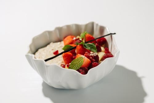 a bowl of oatmeal with strawberries and mint at The Hotel Ljubljana in Ljubljana