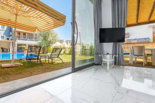 a living room with sliding glass doors and a tv at Nur Suites & Hotels in Kalkan