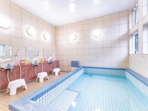 - Baño con piscina, lavamanos y espejos en Hirononomori Maehama Bekkan Male Only, en Hirono