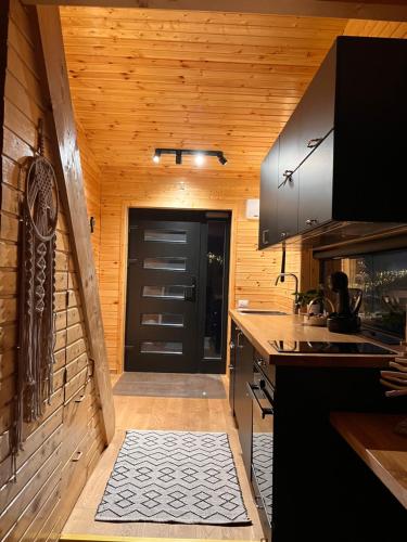 a kitchen with a black door and a counter top at MoodySun Studio, remote tiny home in Comarnic