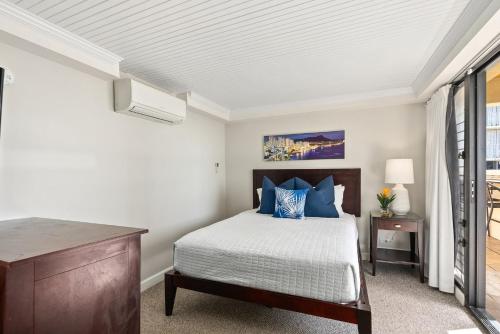 a bedroom with a bed and a desk and a window at Expansive Lanai w/ Panoramic Views - Walk to Waikiki Beach in Honolulu