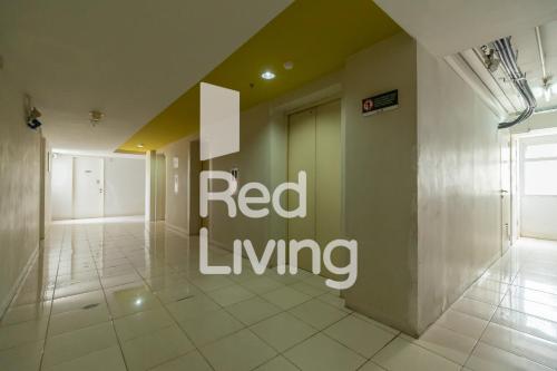a hallway with a red living sign on a wall at RedLiving Apartemen Kalibata City - SAG Property Tower Kemuning in Jakarta