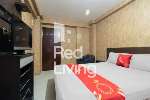 a bedroom with a bed and a flat screen tv at RedLiving Apartemen Kalibata City - SAG Property Tower Kemuning in Jakarta