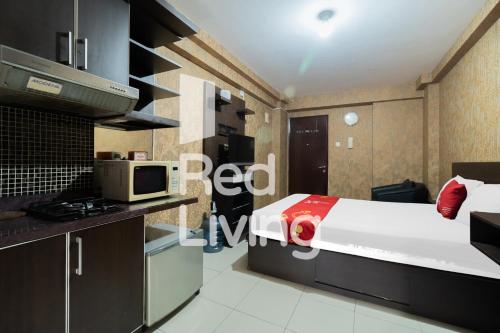 1 dormitorio con 1 cama y cocina con microondas en RedLiving Apartemen Kalibata City - SAG Property Tower Kemuning, en Yakarta
