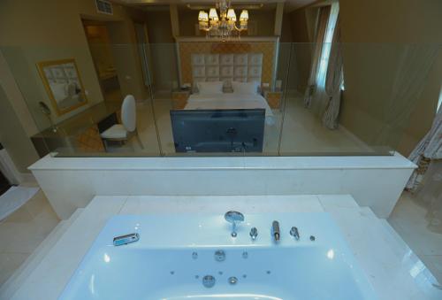 a bathroom with a bath tub and a sink at Gabala Garden Hotel in Gabala