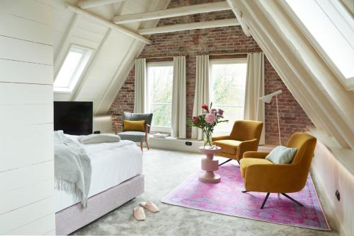 a bedroom with a bed and chairs and a brick wall at Five Rooms in Leer
