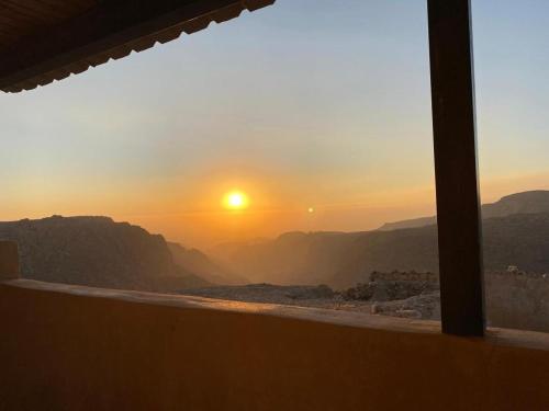 a sunset seen from a window with a view of the mountains at Dana Tower Hotel in Dana