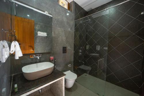 a bathroom with a sink and a toilet and a shower at Yellow Tail by Puggles Resorts in Rāmnagar