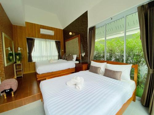 a hotel room with two beds and a window at ภูฝ้ายวิลล่า Phufai villa in Chiang Khan