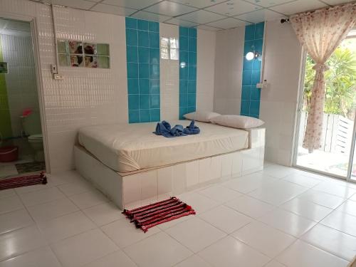 1 dormitorio con 1 cama y baño con ducha en Kanjana Resort, en Suratthani