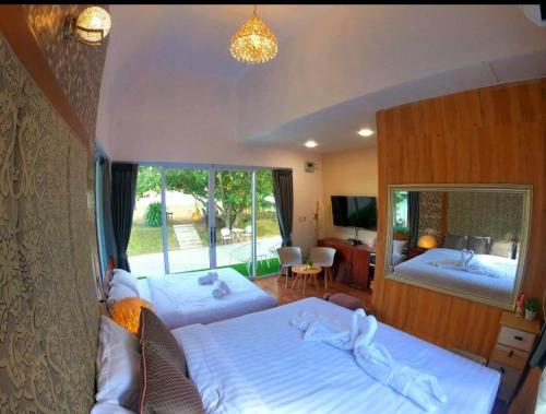 a bedroom with two beds and a large window at ภูฝ้ายวิลล่า Phufai villa in Chiang Khan