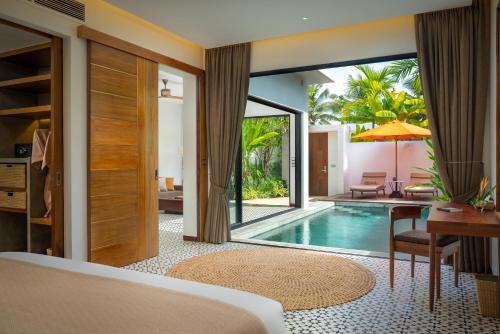 a bedroom with a pool and a bed and a desk at WAKA VILLA Private Pool Resort & Spa - Adults Only in Siem Reap