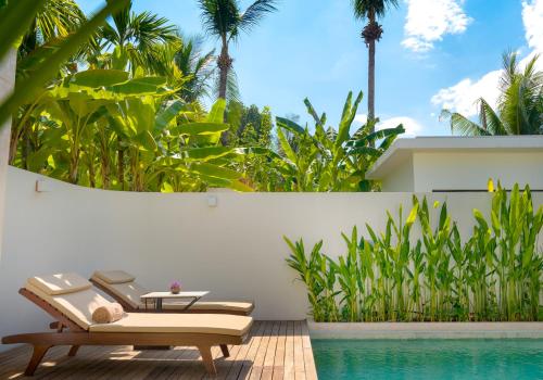 a pool with two chairs and a table next to a house at WAKA VILLA Private Pool Resort & Spa - Adults Only in Siem Reap