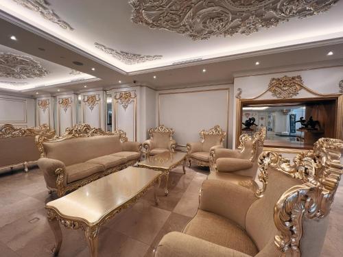 a living room with gold furniture and a ceiling at Puteri Wing - Riverside Majestic Hotel in Kuching