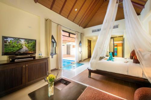 a bedroom with a hanging bed and a tv at Chada Lanta Beach Resort - SHA Extra Plus in Ko Lanta