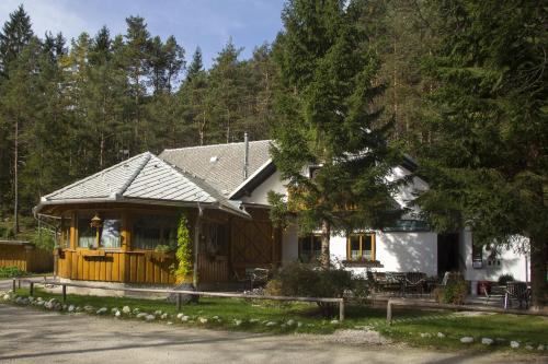 een wit huis met een veranda en een hek bij Guesthouse Draga in Begunje na Gorenjskem