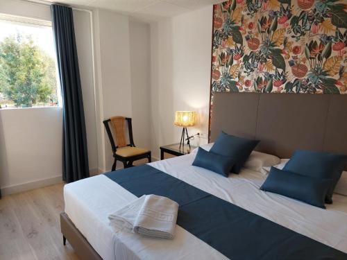 a bedroom with a large bed with blue pillows at Hostal GARDEN ROUS in Paiporta