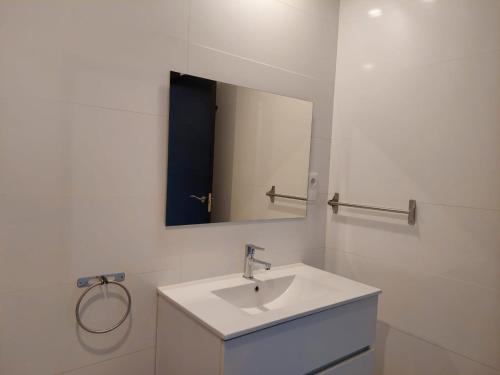 a white bathroom with a sink and a mirror at Hostal GARDEN ROUS in Paiporta