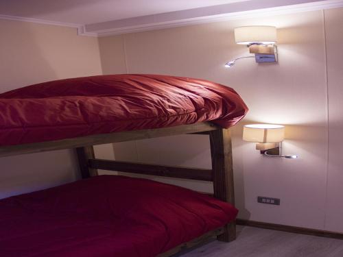 Dois beliches num quarto com luzes na parede em Hostel Entre Vientos em Punta Arenas