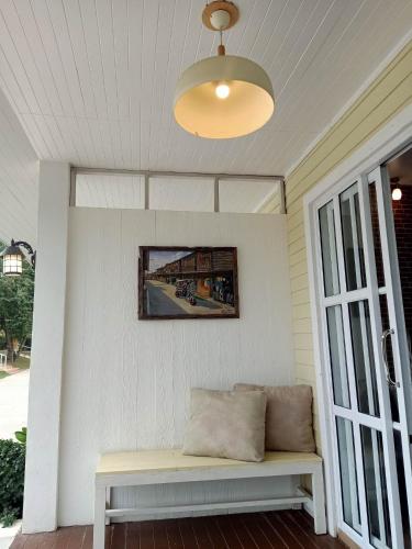 a bench on a porch with a picture on the wall at ภูฝ้ายวิลล่า Phufai villa in Chiang Khan