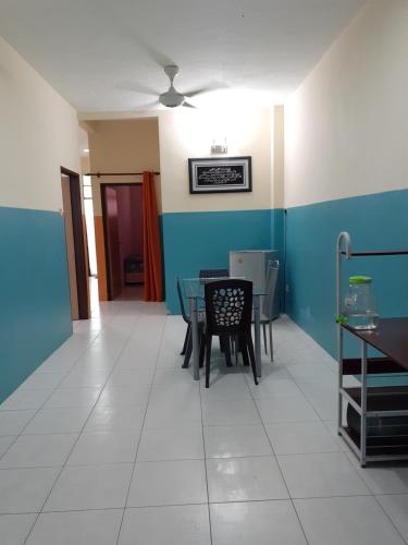 a dining room with blue walls and a table and chairs at Homestay Bukit Kayu Hitam with 3 Bedrooms Not Sharing FREE WIFI in Bukit Kayu Hitam