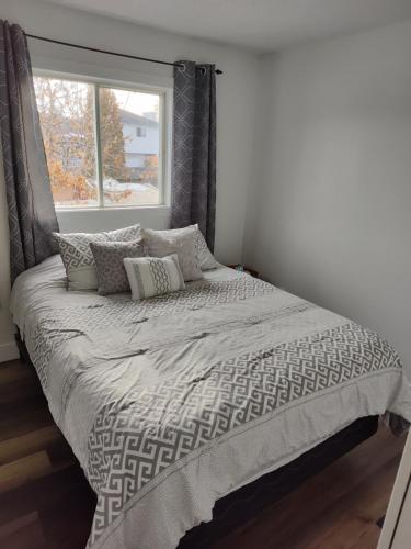 1 cama en un dormitorio con ventana en Tranquil & Tasteful One Bdrm Private Suite NE, en Edmonton